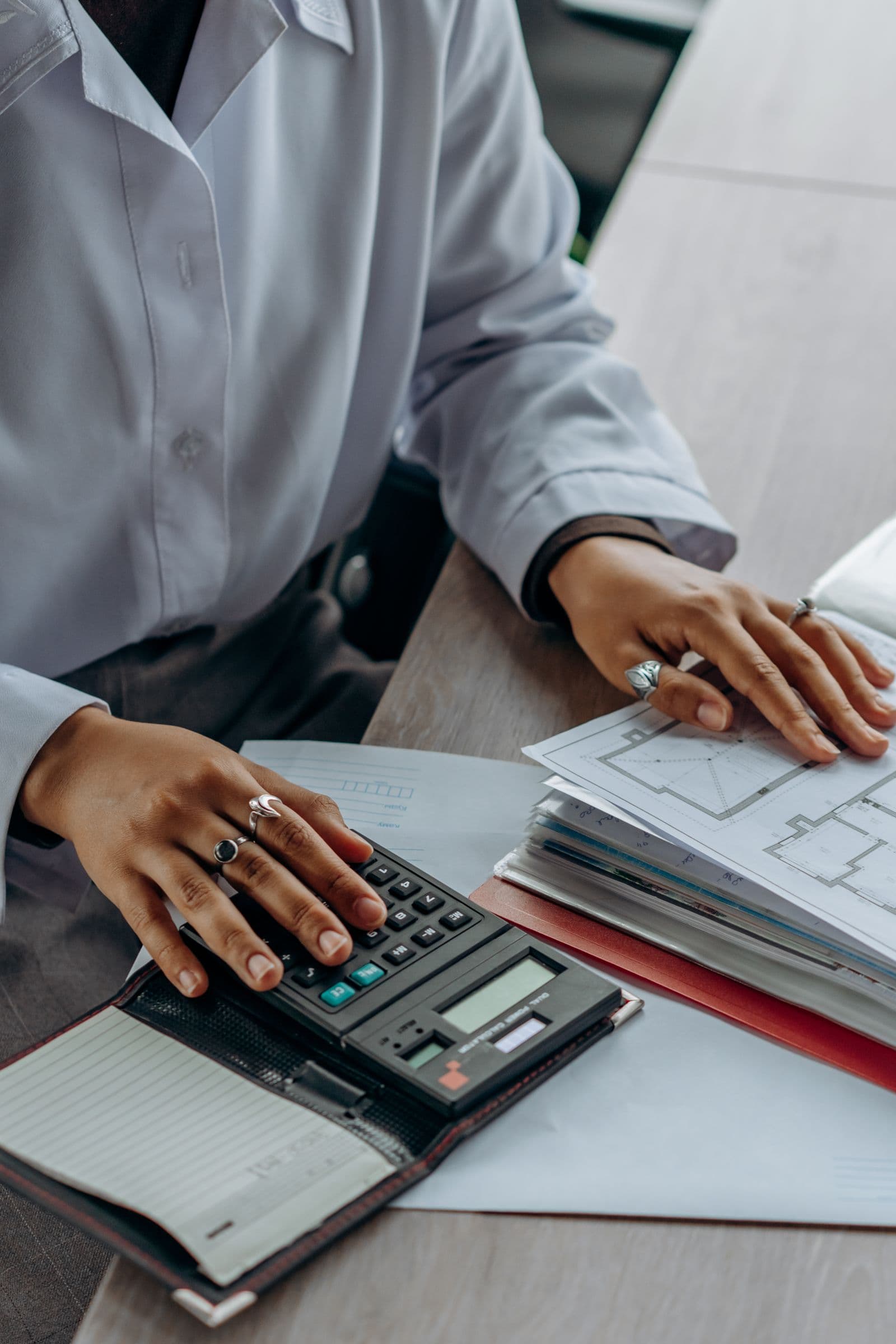 Person reviewing financial documents with a calculator