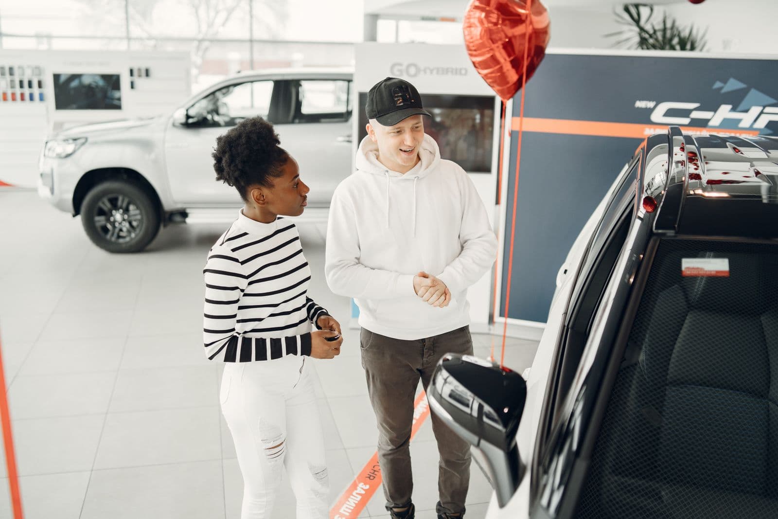 Customers comparing vehicles inside a modern dealership showroom